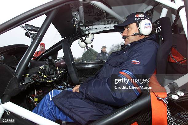Carlos Sainz of Spain and Ford waits for his mechanics to finish their work during the first day of the Network Q Rally of Great Britain in Cardiff,...