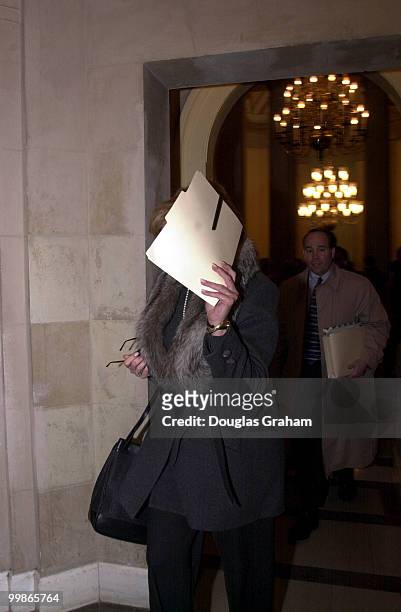 Linda Tripp covers her face as she enters the theme team meeting in the speakers office in the U.S. Capitol.