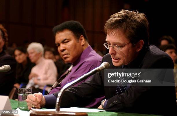 Muhammad Ali, former heavyweight boxing champion listens as Michael Fox, actor/founder, Michael Fox Foundation for Parkinson's Research, makes his...