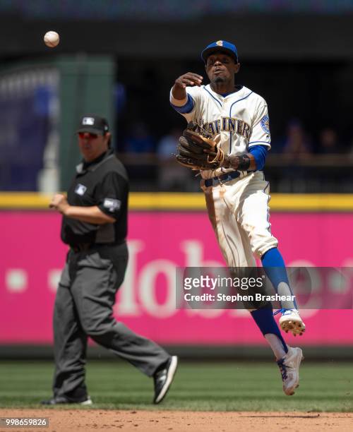 Second baseman Dee Gordon of the Seattle Mariners throws to first base after fielding a ground ball during a game against the Colorado Rockies at...
