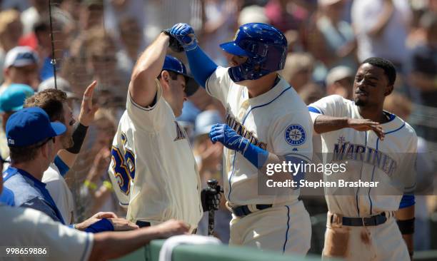 Ryon Healy of the Seattle Mariners is congratulated by teammates David Freitas and Dee Gordon after hitting a home run during a game against the...