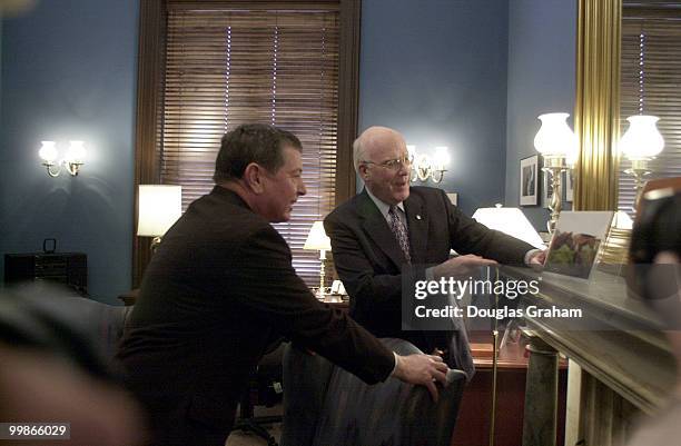 Attorney General nominee, John Ashcroft, R-Mo., and Patrick J. Leahy, D-Vt., check out a photo of Leahy's horses.