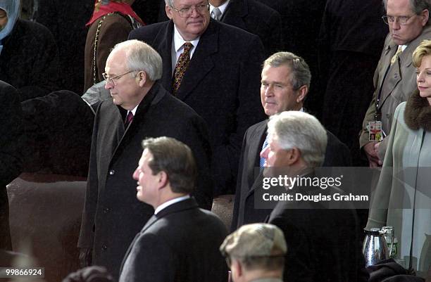 Dick Cheney and George W. Bush wait to be sworn in as Vice President and President as Vice President Al Gore and President Bill Clinton look on...