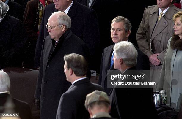 Dick Cheney and George W. Bush wait to be sworn in as Vice President and President as Vice President Al Gore and President Bill Clinton look on...