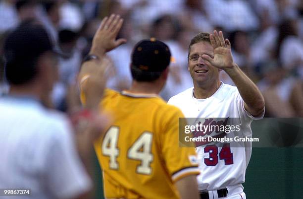 Zack Wamp, R-TN., and Steve Largent, R-OK., high five after Largent scored a first inning run during the 40th Annual Roll Call Congressional Baseball...