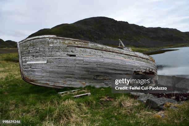 an abandoned wooden boat on the beach of hopseidet, northern norway - finmark stock-fotos und bilder