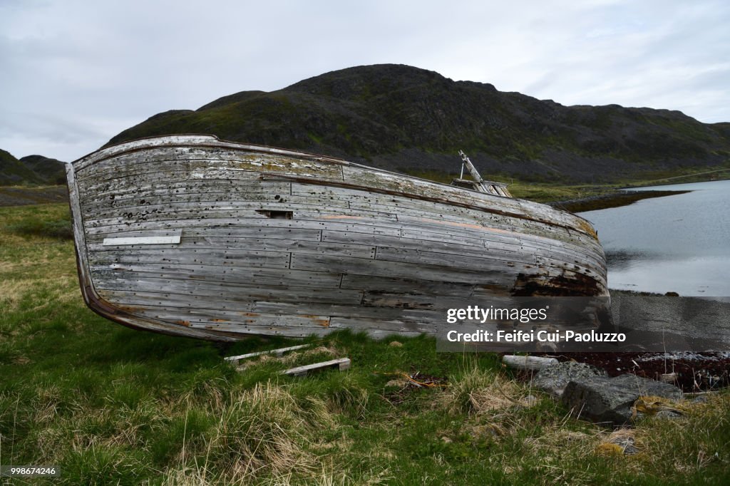 An abandoned wooden boat on the beach of Hopseidet, Northern Norway