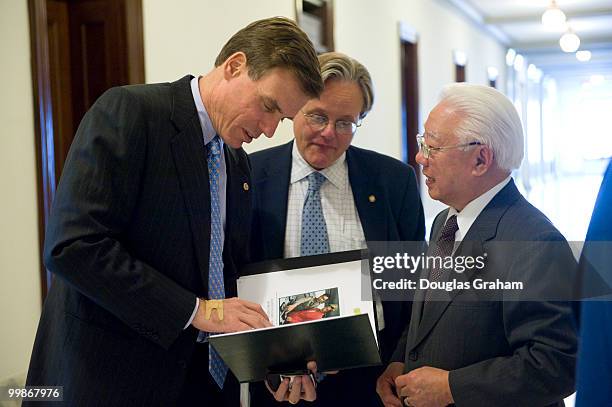 Mark Warner, D-VA., is greeted by H. Benson Dendy III and Captain S. Y. Kuo, Vice Group Chairman, Evergreen America Corporation with a photo album...