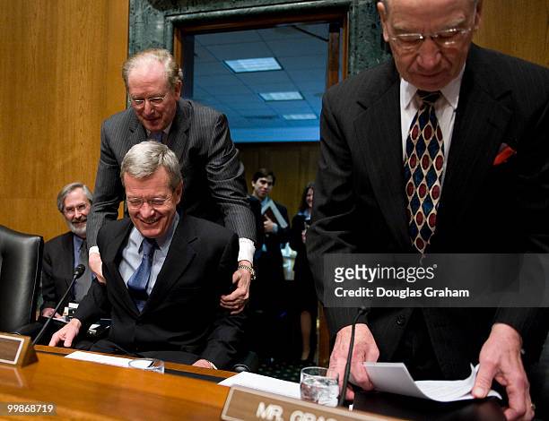 John D. Rockefeller, D-WV., helps a surprised Senator Max Baucus, D-MT., into his seat while Chuck Grassley, R-IA., looks on during a short ceremony...