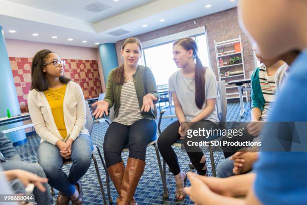 teenage girl talks during support group meeting - teen group therapy stock pictures, royalty-free photos & images