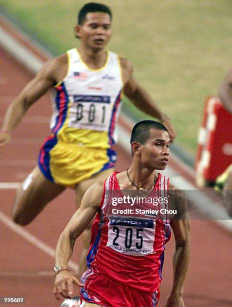 Reanchai Seeharwong of Thailand hits the tape to claim the Gold Medal as Watson Nyambek of Malaysia trailing behind to finish fifth in the Men's 100m...