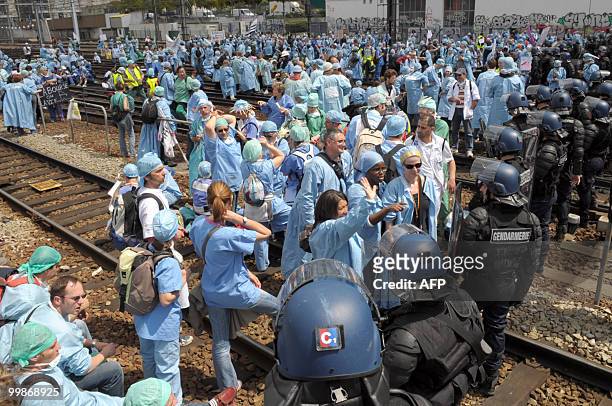 French anaesthetist nurses face policemen as they stand on tracks near the Montparnasse train station on May 18, 2010 in Paris, during a...