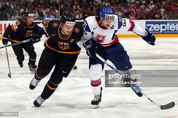 Marcel Goc of Germany vies for the puck with Marek Zagrapan of Slovakia during the IIHF World Championship qualification round match between Slovakia...