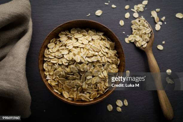 flat lay bowl of delicious oat flakes oatmeal with wood spoon  o - rauw voedsel dieet stockfoto's en -beelden