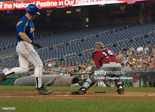 Mike McIntyre, D-NC., scores as Gresham Barrett, R-SC., during the 47th Annual Roll Call Congressional Baseball Game at Nationals Park in Washington,...