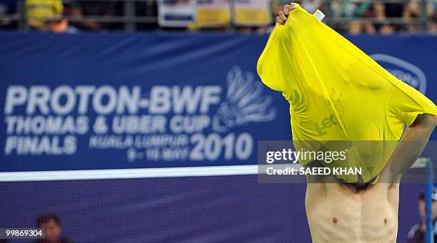 China's Lin dan removes his shirt to celebrate his victory over Malaysia's Chong Wei Lee during their semi-final singles match in the Thomas Cup...