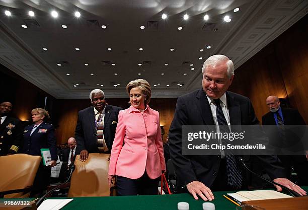 Secretary of State Hillary Clinton and Defense Secretary Robert Gates find their seats before testifying to the Senate Foreign Relations Committee...