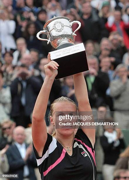 Russia's Svetlana Kuznetsova holds up the trophy after winning against Russia's Dinara Safina during the French Open tennis final match on June 6,...