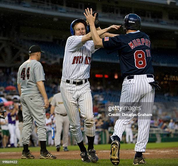 Christopher Murphy, D-Conn., and Patrick Murphy, D-PA., high-five after scoring a run during the 48th Annual Roll Call Congressional Baseball Game on...