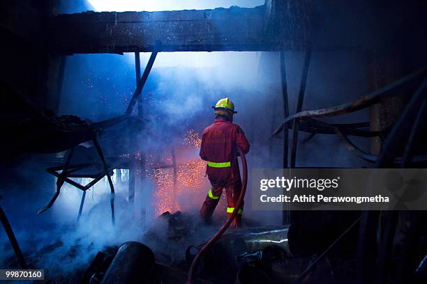 Firefighters work to control a blaze started by anti-government red shirt protesters on May 18, 2010 in Bangkok, Thailand. Protesters have clashed...