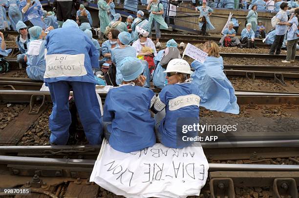 French anaesthetist nurses sit on tracks near the Montparnasse train station on May 18, 2010 in Paris, during a demonstration blocking the speed...