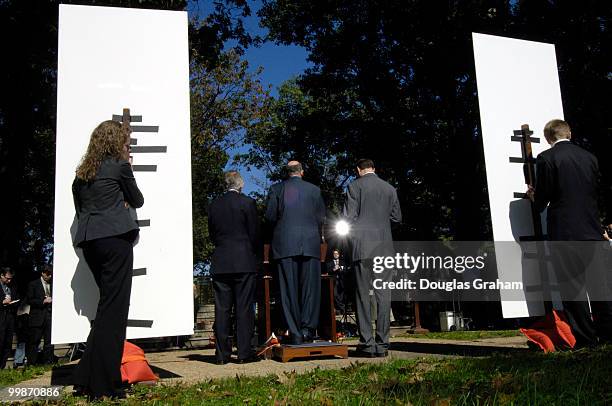 Staffers from Democratic Leader Harry Reid's office Kristine Willie and Nick Weeks hold up signs during a press conference to keep the wind from...