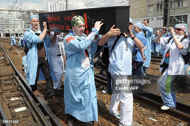 French anaesthetist nurses carry a coffin as they demonstrate on tracks near the Montparnasse train station on May 18, 2010 in Paris, during a...