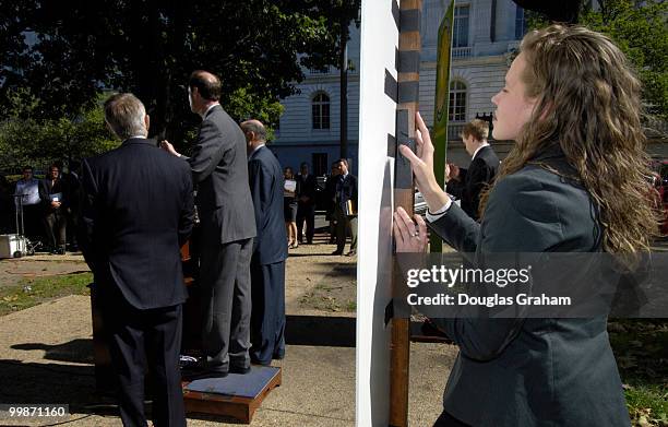 Staffers from Democratic Leader Harry Reid's office Kristine Willie and Nick Weeks hold up signs during a press conference to keep the wind from...