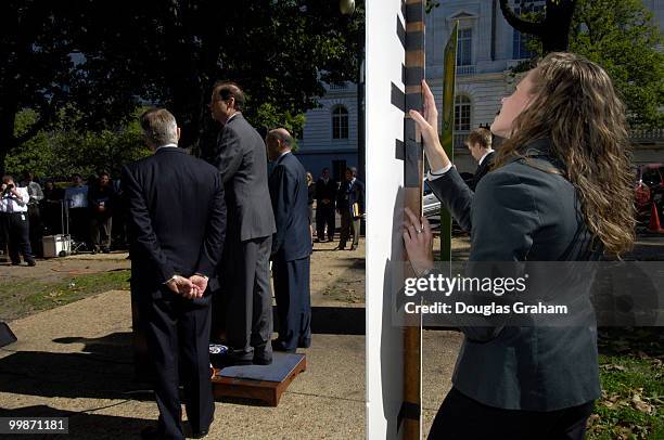 Staffers from Democratic Leader Harry Reid's office Kristine Willie and Nick Weeks hold up signs during a press conference to keep the wind from...