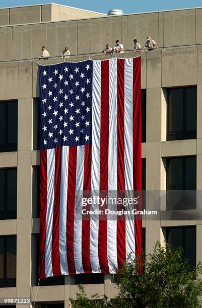 Employees of the United States Department of Labor lower a huge American flag during the moment of silence to remember the dead from the September...