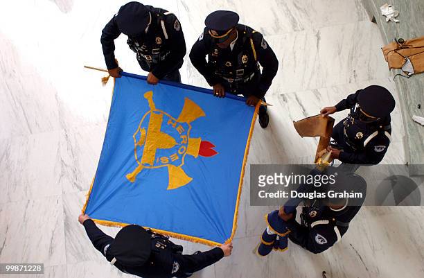 Members of the United States Capitol Police Ceremonial Unit roll up the "Hero's" flag after staffers and members of the Rayburn House Office Building...