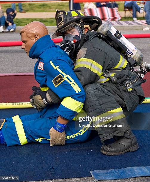 Here a firefighter picks up "rescue Randy" during the Firefighter Combat Challenge. The event attracts hundreds of U.S. And Canadian municipal fire...