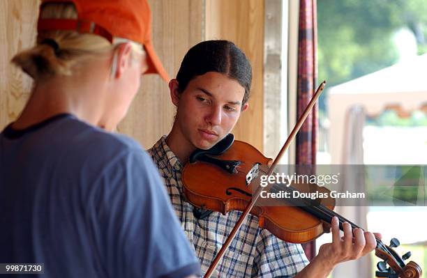 Hermann Jayne and David Langmaid take time to learn a new song before the opening ceremony of the 37th annual Smithsonian Folklife Festival on the...