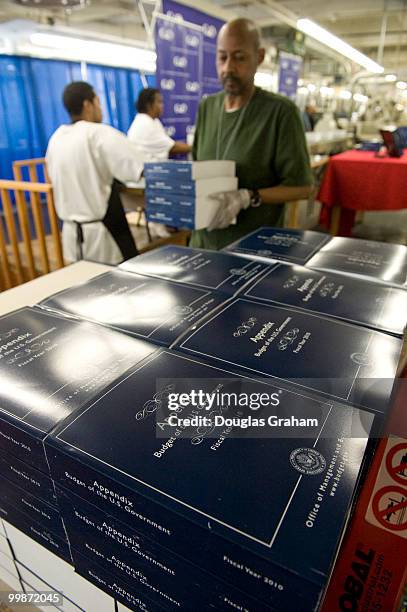 Employees work on President Barack Obama's detailed budget book during a production run in preparation for the release of the budget to be...