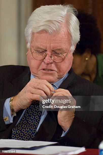 Chairman Edward Kennedy, D-Mass. Pins a AIDS/HIV pin on his jacket lapel before the start of the full committee hearing on "Meeting the Global...