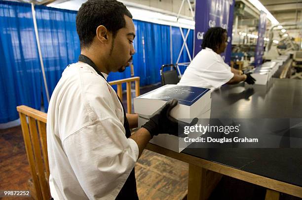 Employees work on President Barack Obama's detailed budget book during a production run in preparation for the release of the budget to be...