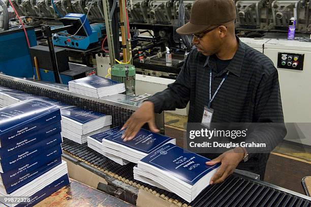 Employees work on President Barack Obama's detailed budget book during a production run in preparation for the release of the budget to be...