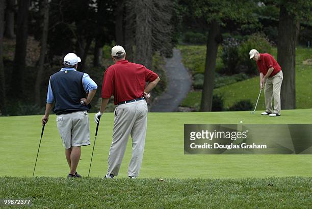 Mike Doyle and Mike Oxley watch Ander Crenshaw putt during the First Tee Congressional Challenge golf tournament at Columbia Country Club in Chevy...