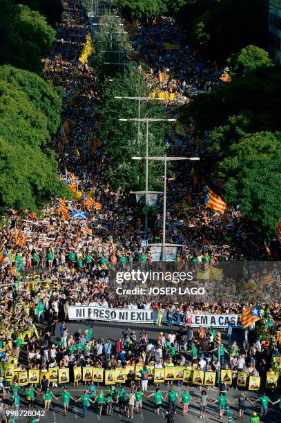 People holding a banner reading "No jail, No exile" attend a demonstration on July 14, 2018 in Barcelona, calling for the release of separatist...