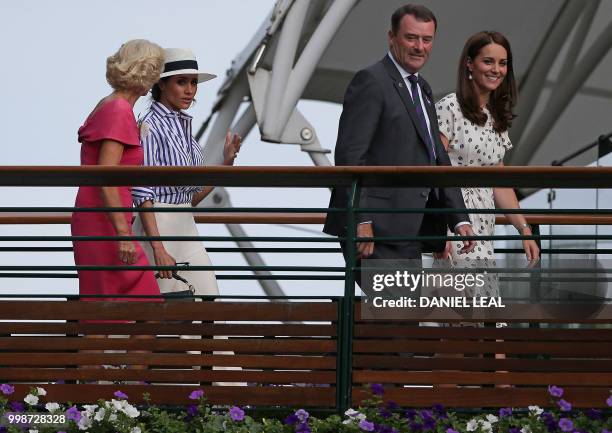Britain's Catherine, Duchess of Cambridge, and Meghan, Duchess of Sussex walk with Philip Brook , Chairman of the All England Lawn Tennis Club, and...