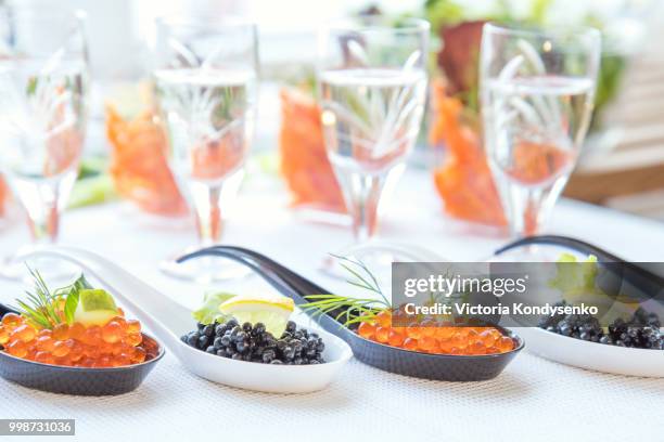 red and black caviar fish in white, black spoons - red caviar stock pictures, royalty-free photos & images