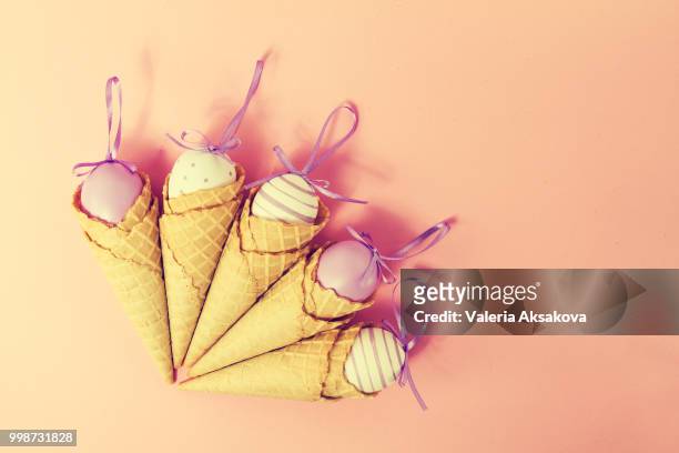 colorful ice cream cones with easter eggs on pink background. va - comportamientos de la flora fotografías e imágenes de stock