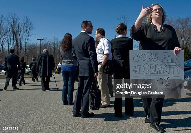 Reagan Blewitt a staffer for Mark Warner's office holds up a sign saying that the job fair is closed leaving hundreds with no hope of entry to the...