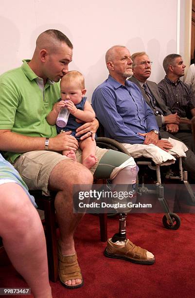 Staff Sergeant Justin Shellhammer who lost his leg to a land mine in Afghanistan gives his 8-month-old daughter Alexis a kiss during the press...