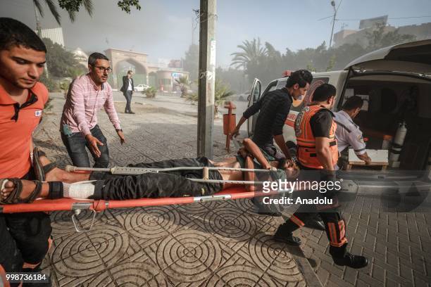 Wounded Palestinian man is being taken to the hospital after Israeli fighter jets pounded Al Katiba region in Gaza City, Gaza on July 14, 2018.