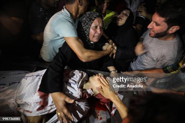 Relatives mourn over Amir al-Nimra's dead body at al-Shifa hospital after Israeli warplanes carried out airstrikes across the Gaza Strip in Gaza...