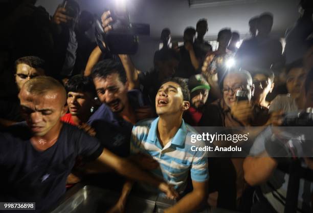 Relatives mourn at al-Shifa hospital as dead bodies are being brought after Israeli warplanes carried out airstrikes across the Gaza Strip in Gaza...