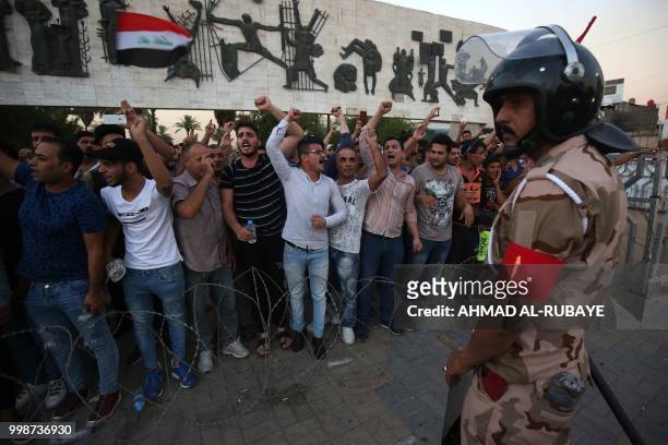 Member of the Iraqi security forces stands guard as protesters in the capital's Tahrir Square demonstrate against unemployment on July 14, 2018. -...