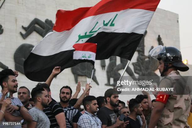 Member of the Iraqi security forces stands guard as protesters in the capital Baghdad's Tahrir Square demonstrate against unemployment on July 14,...
