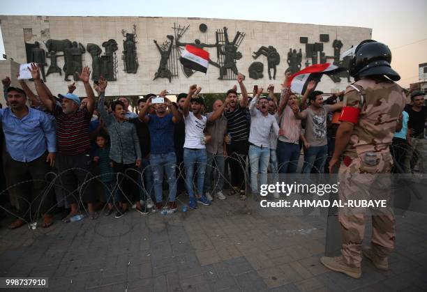 Member of the Iraqi security forces stands guard as protesters in the capital Baghdad's Tahrir Square demonstrate against unemployment on July 14,...